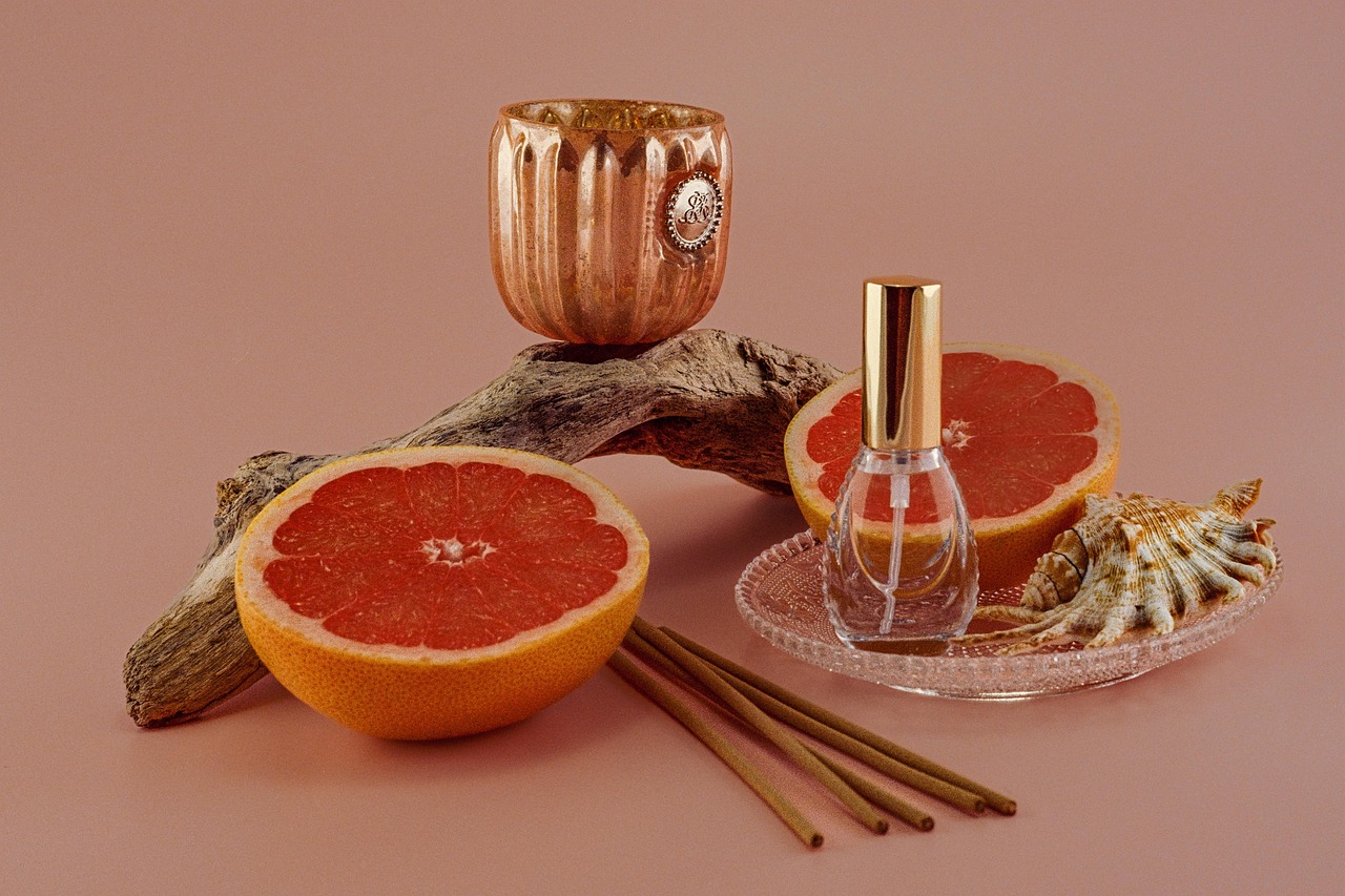 Citrusgeurkaarsen met pastelgekleurde achtergrond.